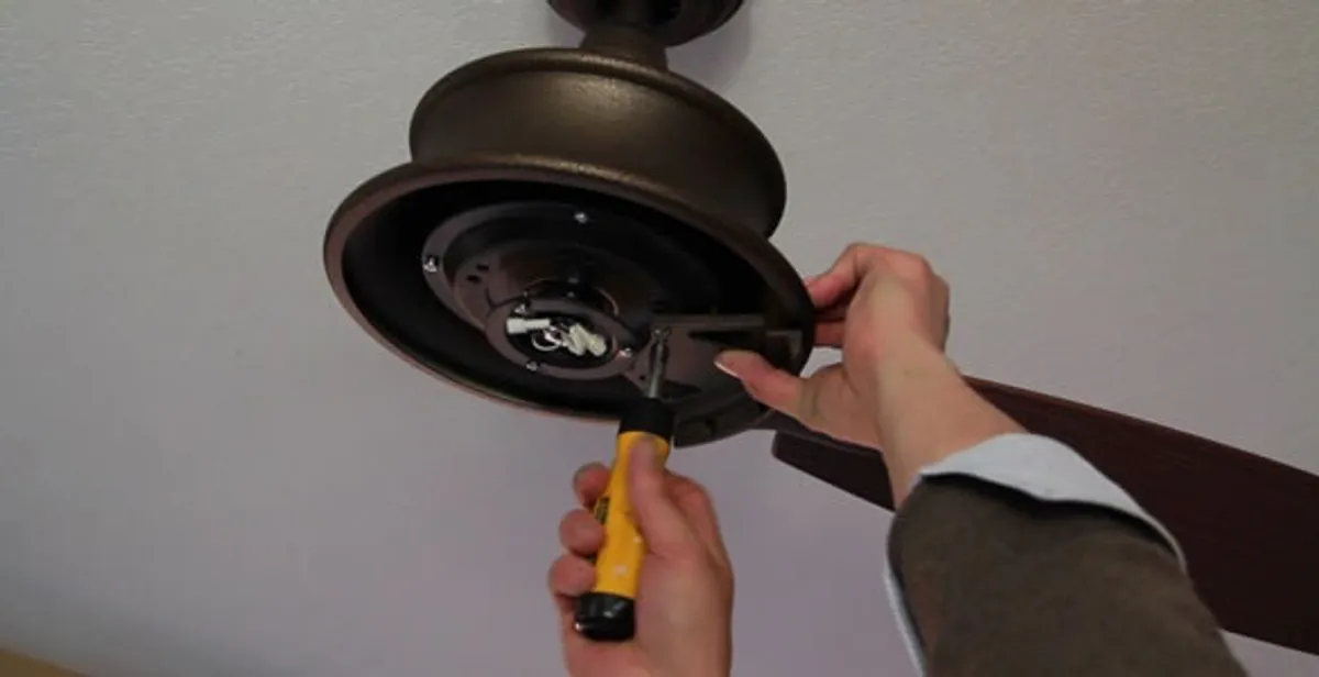 Electrician installing ceiling fan mounting bracket and fixture in Naperville, IL