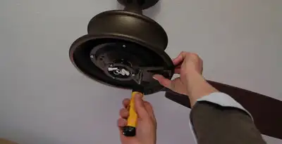 Electrician installing ceiling fan mounting bracket and fixture in Naperville, IL
