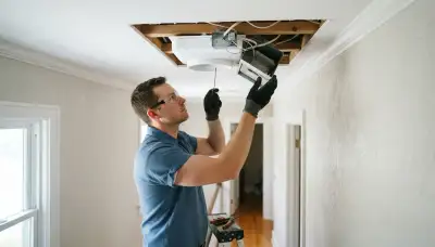Electrician installs a whole-house fan ceiling unit and insulated damper in a Naperville, IL home