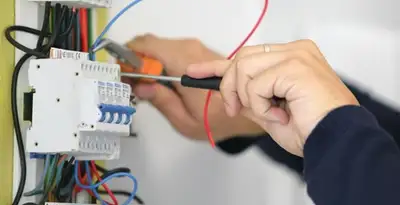 Electrician installing and adjusting circuit breakers in an electrical panel in Naperville, IL