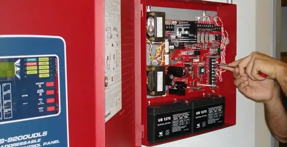 fire alarm installation service showing technician configuring fire alarm control panel in Naperville, IL