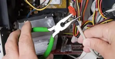 Licensed electrical contractor performing electrical repair with tools in Warrenville, IL