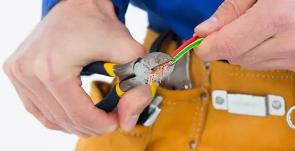 licensed electrician securing electrical wiring with professional tools during service work in Naperville, IL