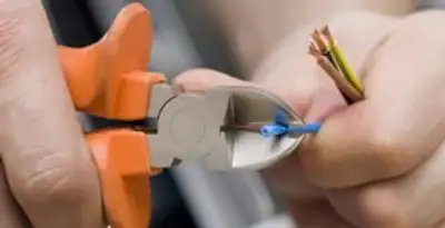 licensed electrician performing precise wire cutting and preparation during electrical service in Naperville, IL