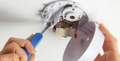 Certified technician wiring smoke detector during installation in Naperville, IL